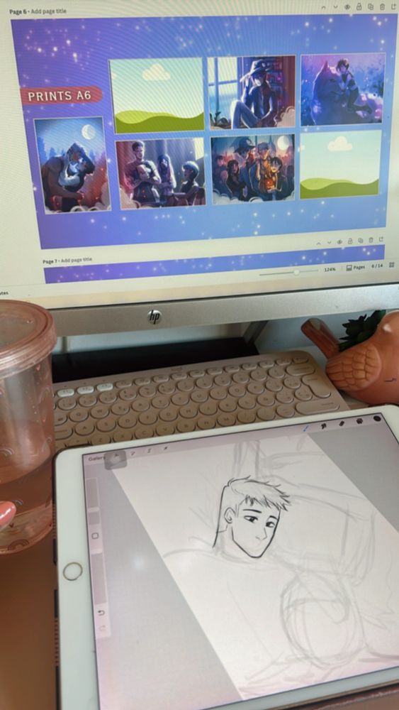 Fotografía de escritorio en el que se ve en la pantalla del ordenador unas ilustraciones en tonos azules y en el iPad junto al teclado, un dibujo en proceso