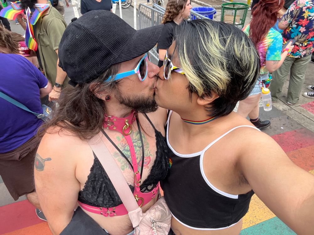 Me and my bf smooching at Philly Pride, with the rainbow crosswalk in the background