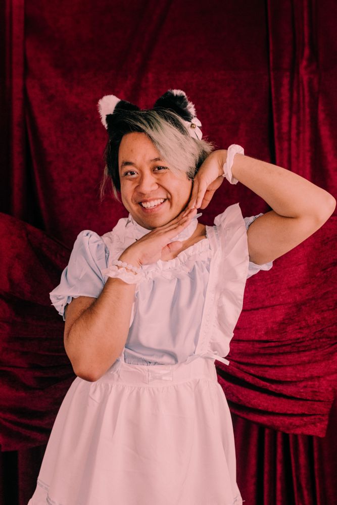 Chris posing wearing cat ears and a light blue maid outfit