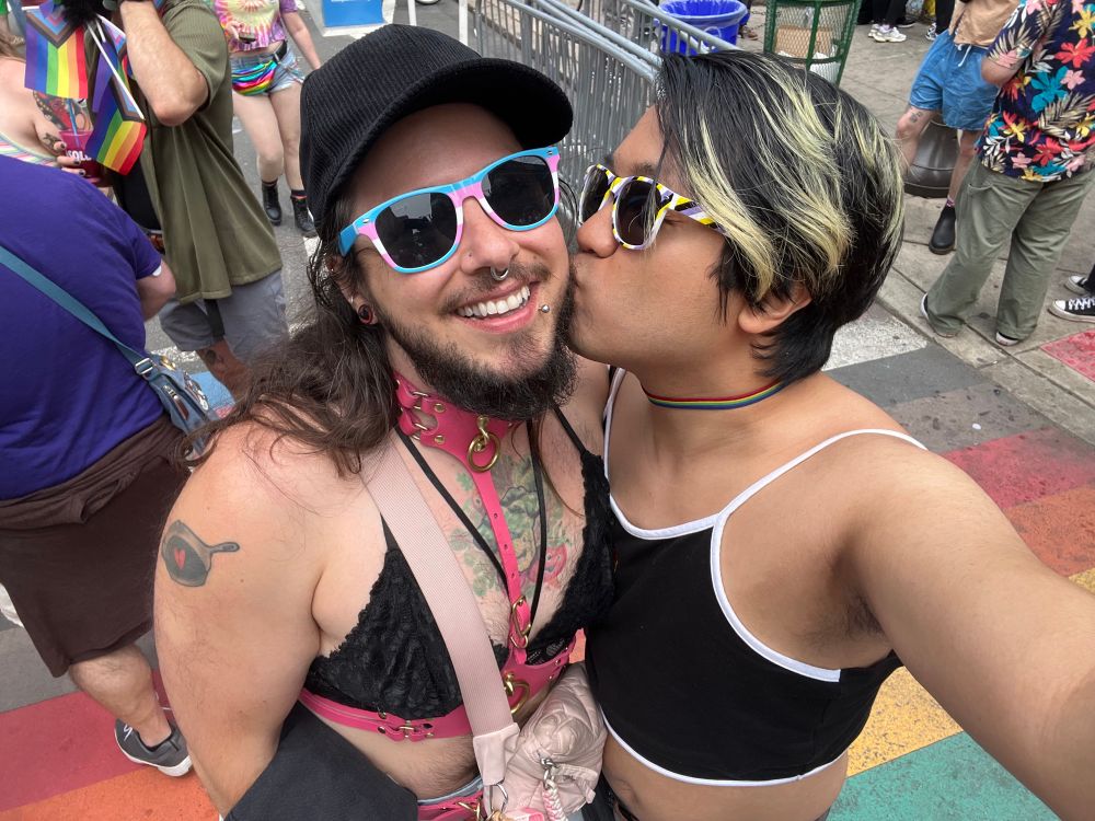 Me giving my bf a cheek smooch at Philly Pride, with the rainbow crosswalk in the background