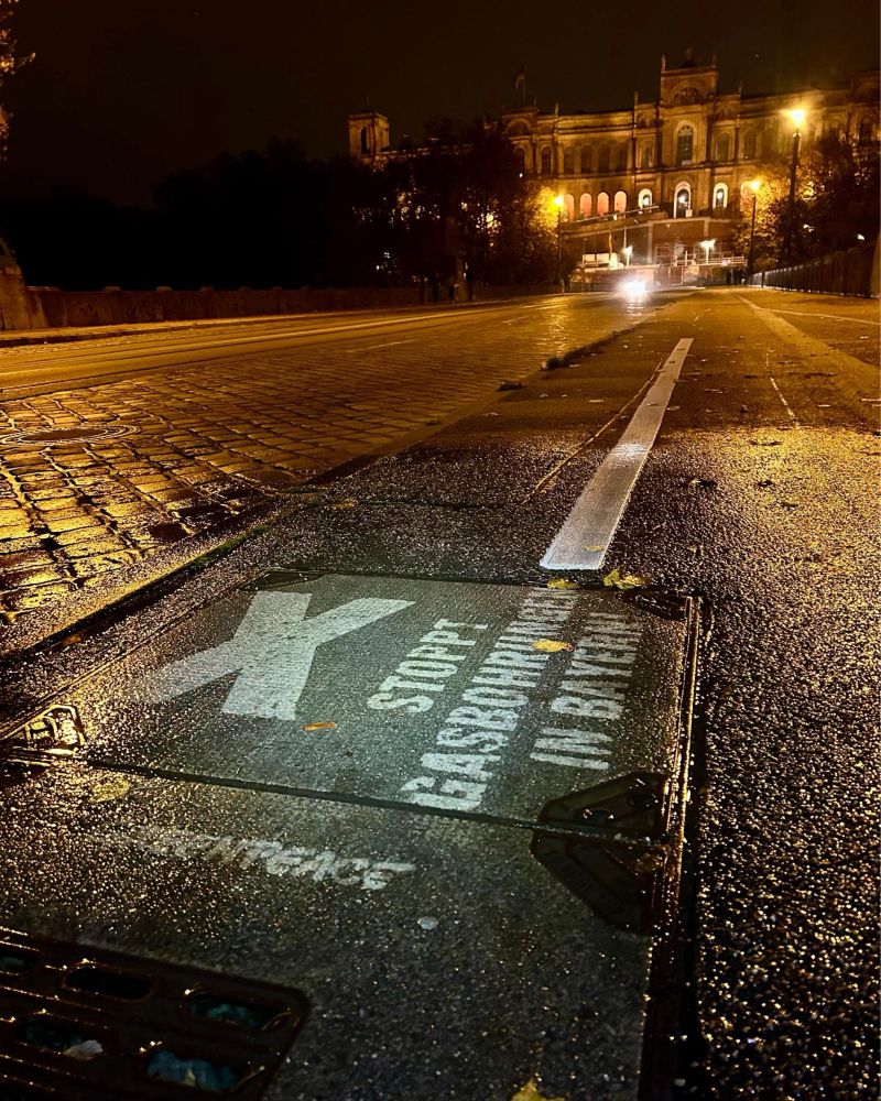 Das Foto zeigt ein Reverse Graffiti mit der Aufschrift „Stoppt Gasbohrungen in Bayern“ vor dem Maximilianeum.