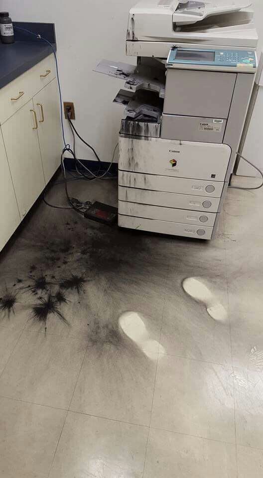 doctor's(?) office with a photocopier, a floor full of toner and a suspiciously clean pair of shoe prints