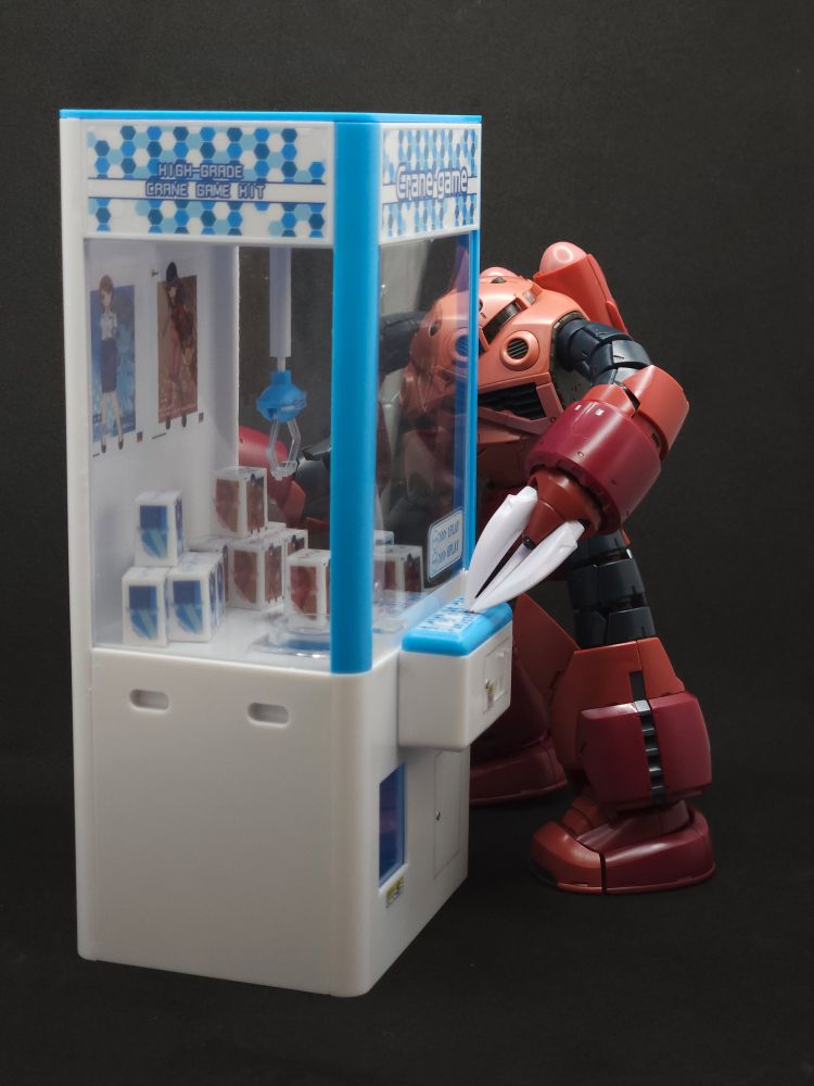 Z'gok looking around the side of the crane game to line up the crane