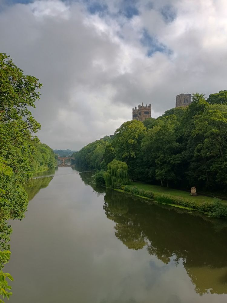 The river Wear at Durham, the towers of the cathedral peaking above the trees
