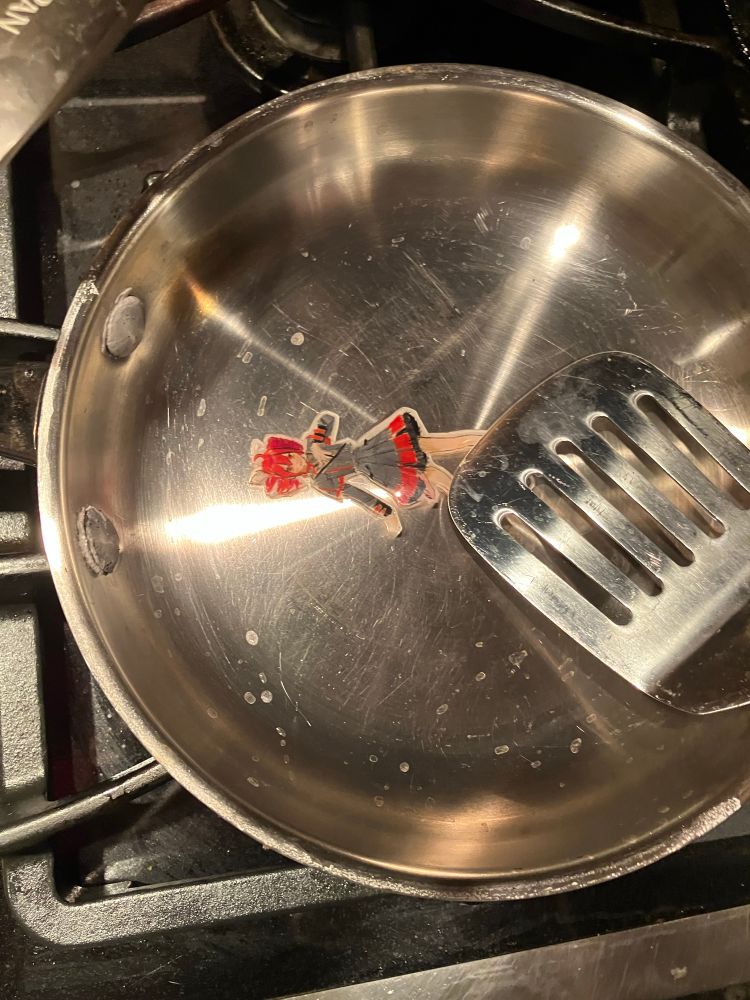 a spatula touching the teto in the frying pan