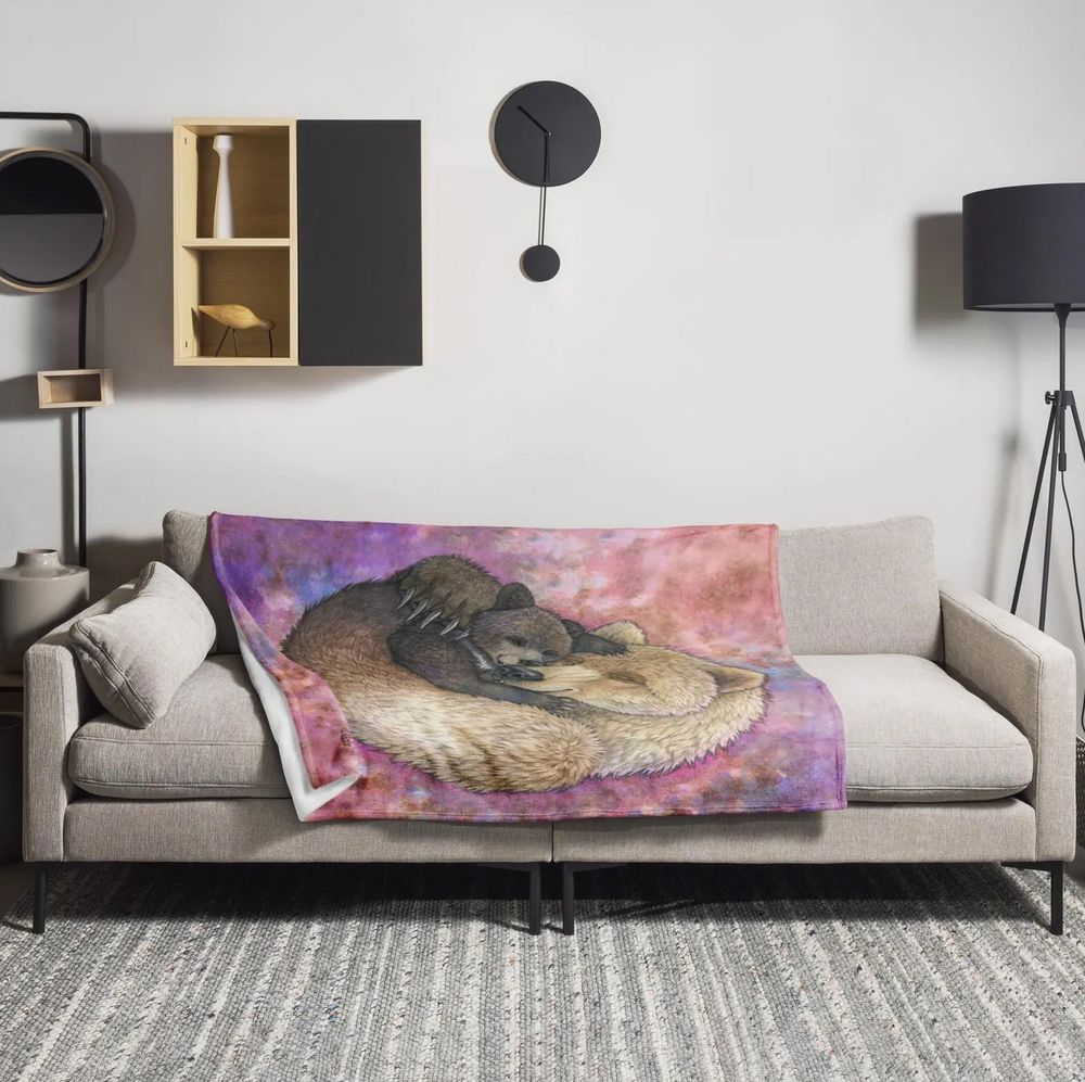 Minky blanket thrown over a sofa featuing an image of a mother bear cuddling her baby bear
