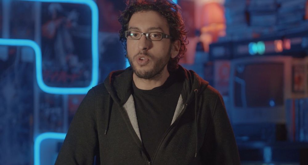 Karim Debbache avec un pullover avec l'intérieur gris