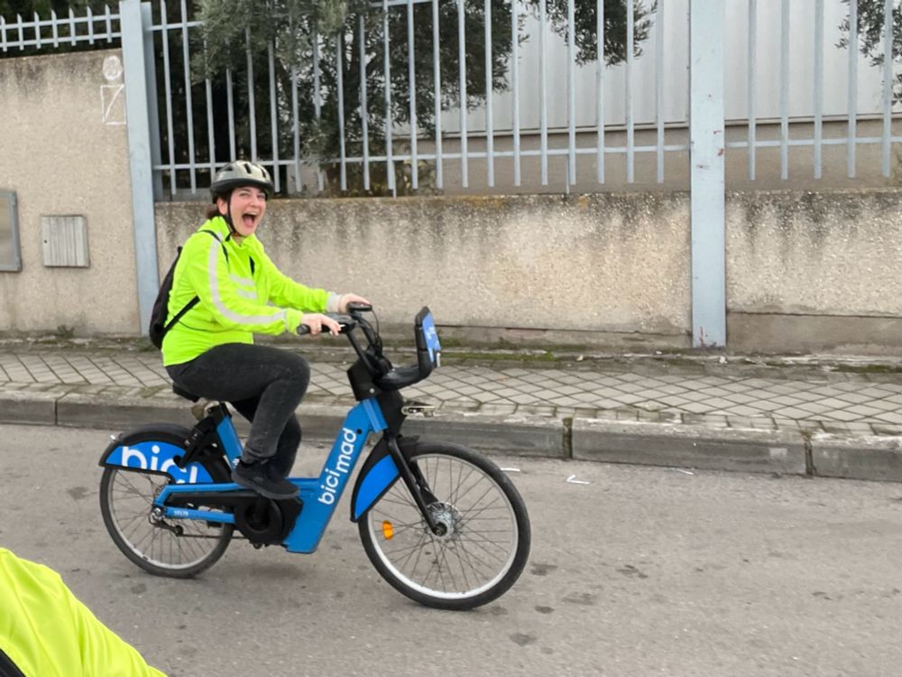 Yo misma subida en una bici, con chaqueta amarilla cantosa y cara de felicidad. 