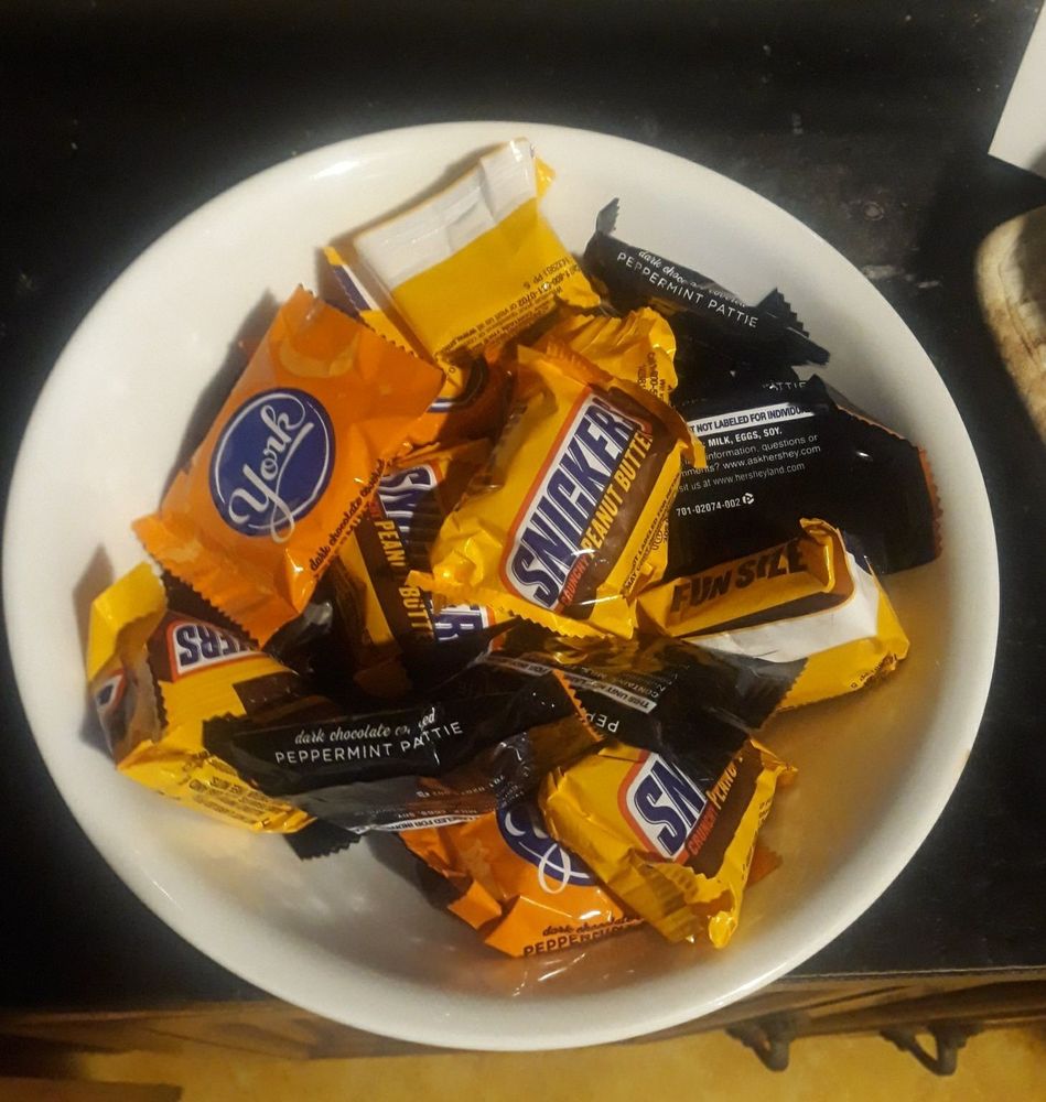 White bowl holding "fun size" Halloween York peppermint patty and Snickers Peanut Butter candy.