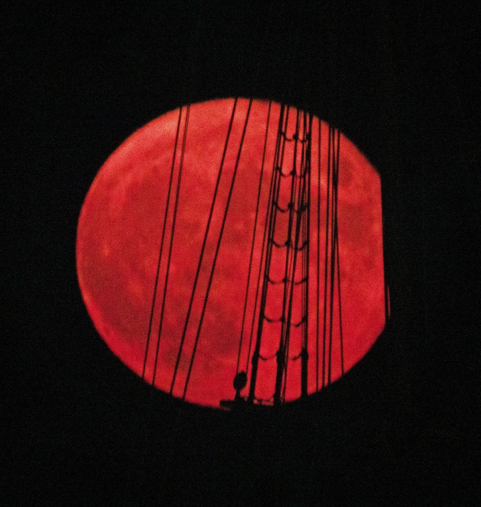 A blood red full moon through the ridding of the Mayflower; Plymouth, MA.
