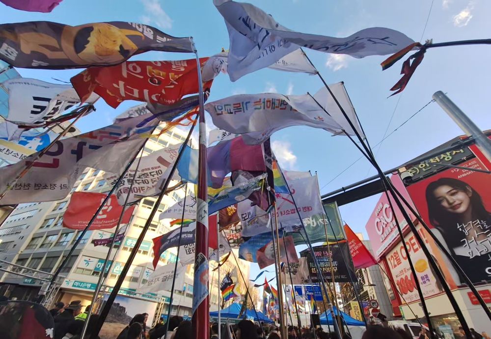 집회의 다양한 깃발들이 바람에 휘날리고 있다.