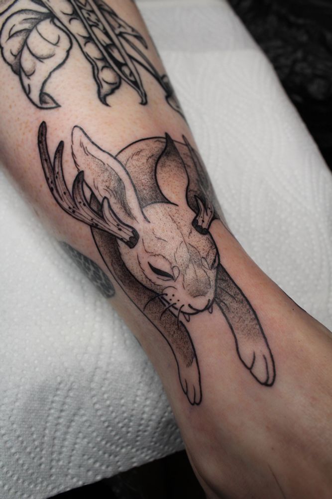 A wolpertinger tattoo - a hare wit antlers and fangs 
