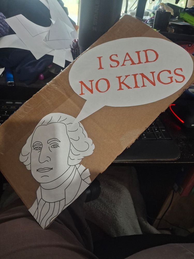 Speech bubble with "I said no kings" pointing at George Washington. Both George and the bubble are cut out of printer paper and attached to a chunk of cardboard which used to be part of a box.