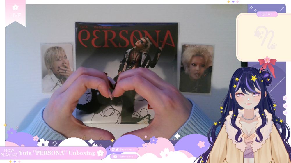 A screenshot of VTuber Nova Eos's unboxing stream of Yuta's "PERSONA" albums from November 17, 2025. Nova's Live2D model is positioned to the bottom right corner and can be seen from the waist up. She is smiling. The game overlay has a "Now Playing" section where "Yuta 'PERSONA' Unboxing" has been showcased in white text. The gaming overlay is Nova's handcam where a copy of Yuta's album is sitting in the middle of the screen with two photocards of him on either side. Nova's hands are seen forming a heart on top of the album.