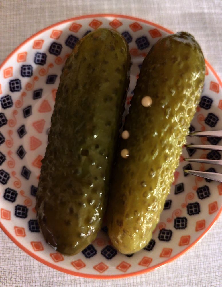 zwei essiggurken auf einem kleinen tellerchen