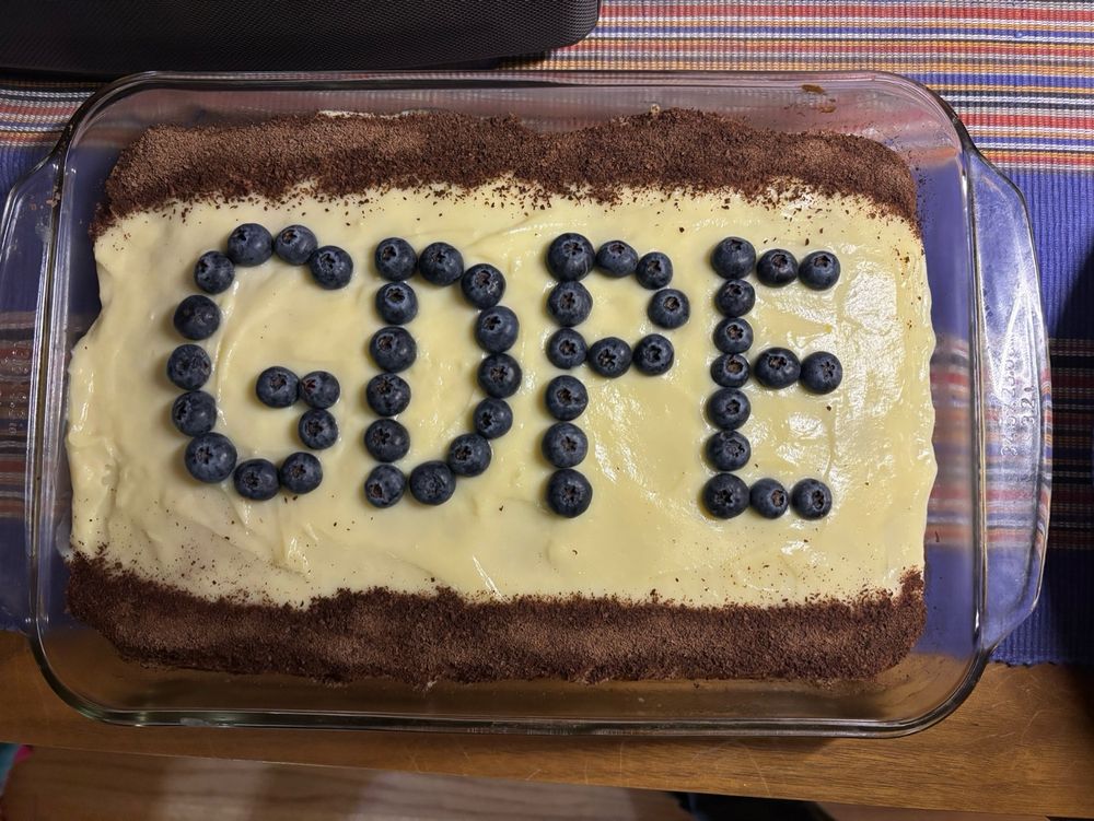 Picture of a cake with berries on top that spell GDPE, which stands for graduate degree program in ecology