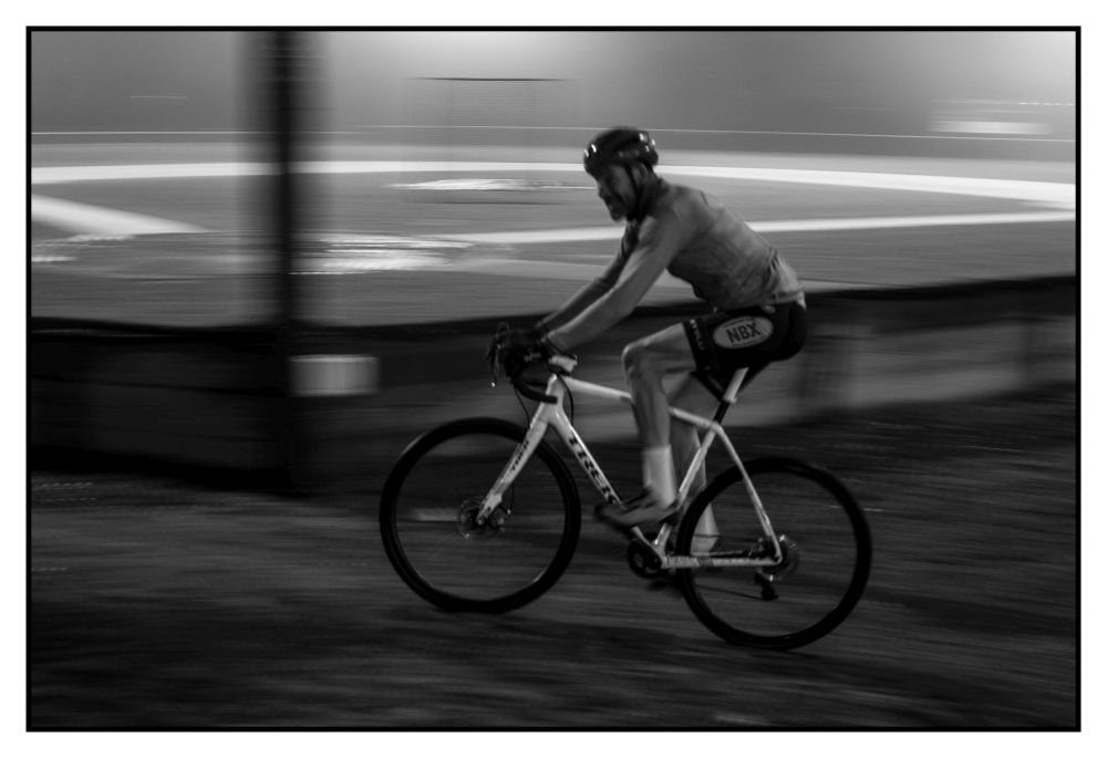 racing up a slight rise in the course with the baseball field in the background