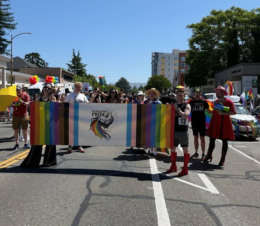 A photo of folks gathered around the Petaluma Pride banner for the parade.