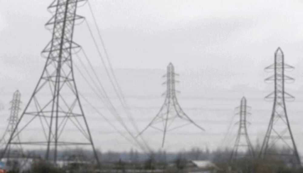 a blurred image of a row of power lines with a cloudy sky in the background