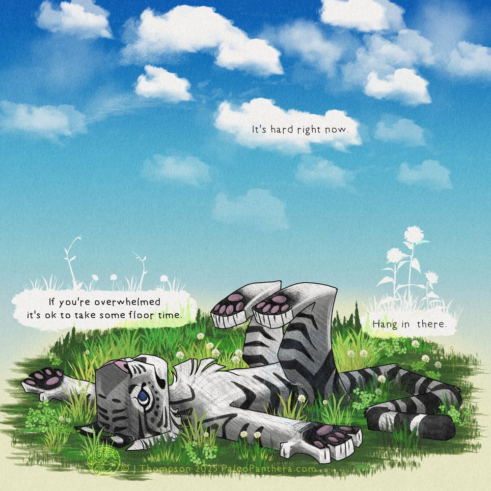 A cartoony gray tiger character is lying on the ground face up with their arms spread apart and their feet in the air. They are surrounded by grass and clover with a bright blue sky above. There are three lines of text scattered top to bottom through the image. The lines read as follows: "It's hard right now. If you're overwhelmed it's ok to take some floor time. Hang in there." The attitude is tired, and worn, with a little hope.