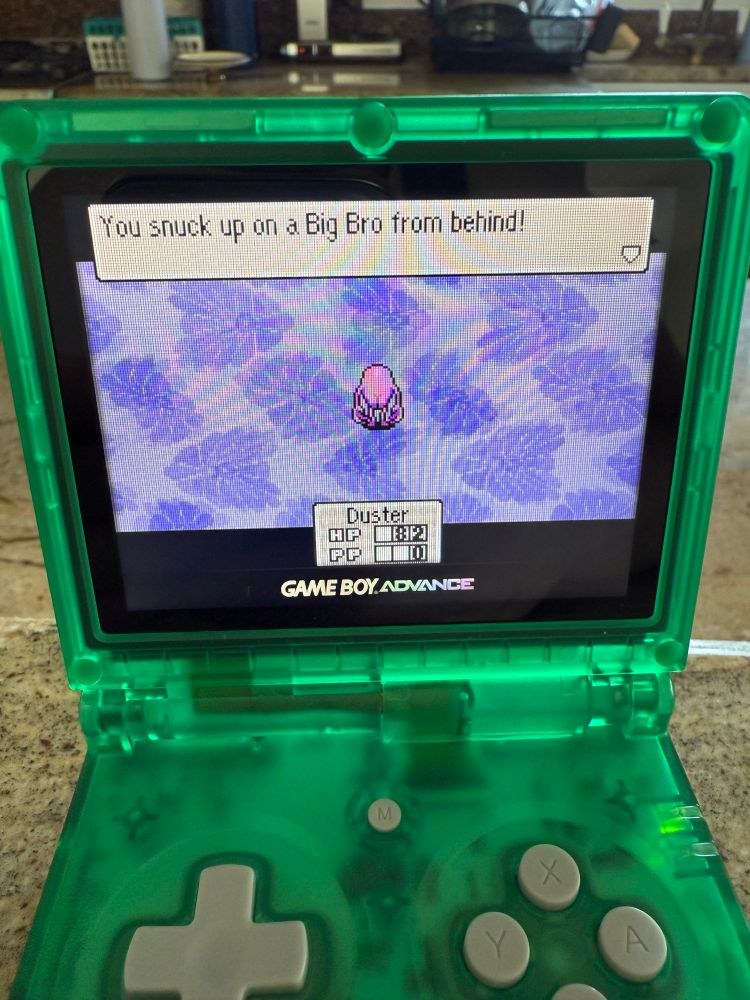 Screenshot from Mother 3 depicting an enemy from behind called Big Bro - who is a pink humanoid blob that is super cheeked up