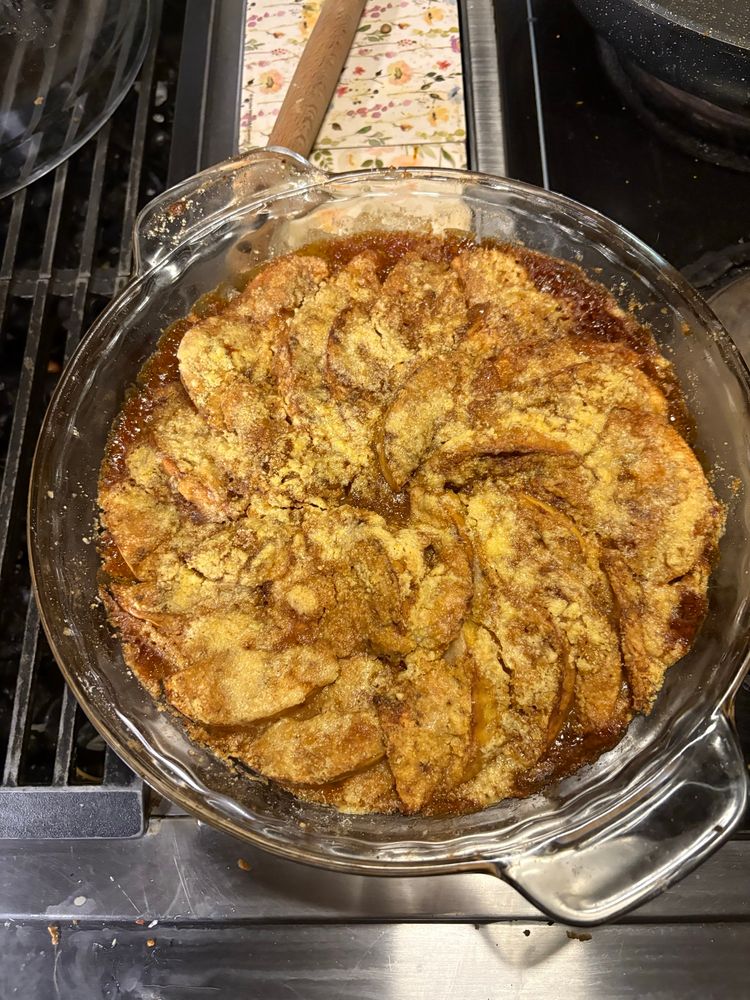 An apple tart. It’s in a circular pie dish apples laid in thin slices in a circular pattern. With a wonderfully golden brown crumble top and slowly caramelized to perfection Honestly I wish you could smell it. It’s amazing. 