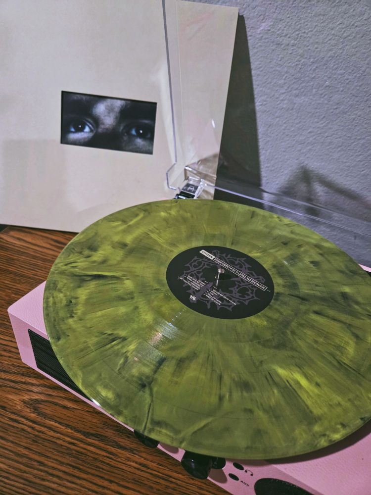 10 year anniversary vinyl of "everybody is going to heaven" by citizen. The record itself is a pretty lime green and black tie dye color. 