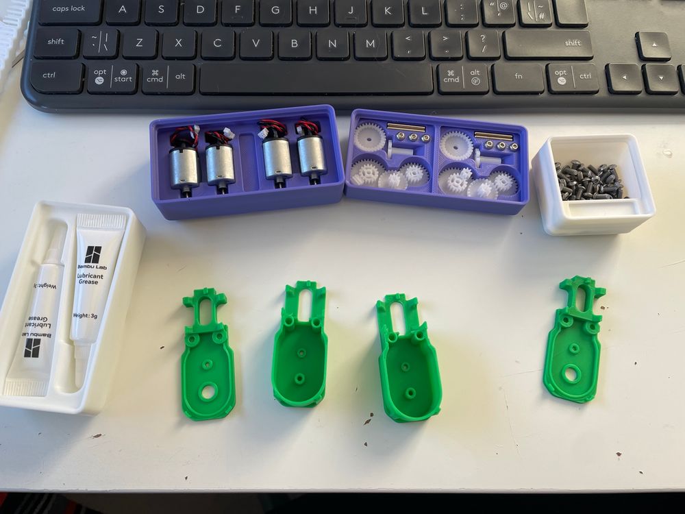 Part trays ready for gearbox assembly.
We have lubricant, dc motors, gear box parts and machine screws above two sets of gearbox housing prints.
