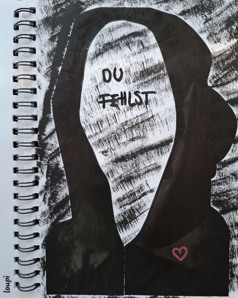 Zeichnung/Collage in einem Spiralbuch mit weissen Seiten. Gross über die ganze Seite ist eine schwarze Kapuze ohne Gesicht hingeklebt. In der Lücke steht: DU FEHLST. Rechts auf dem Pulli ist ein kleines rotes Herz. Der Hintergrund ist schwarz-weiss gemustert. 