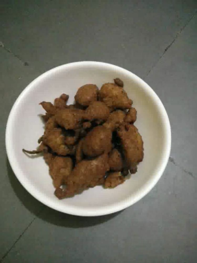 a white bowl filled with fried food is sitting on a table