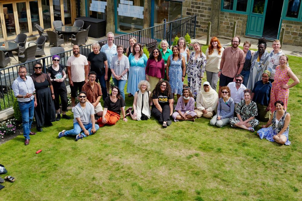 Group photo of 20 or so community members standing on the grass