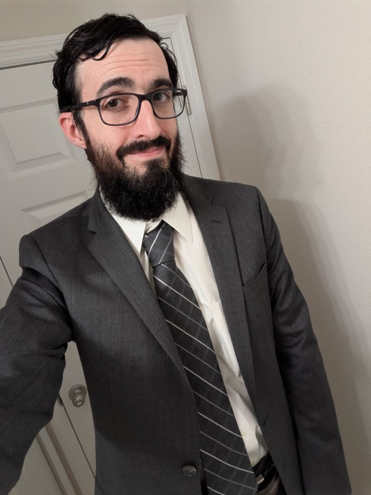 Spectrum Branch dressed up in a suit. The jacket and tie are gray.
