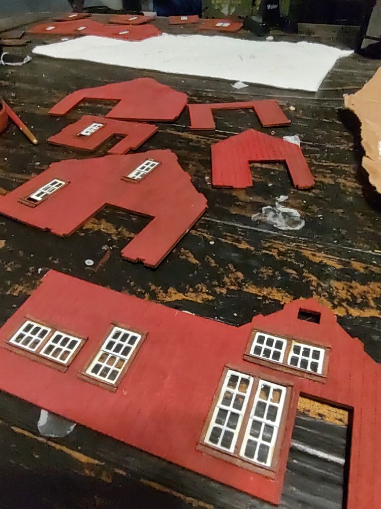 Several walls of a scale model building with finished trimmed windows