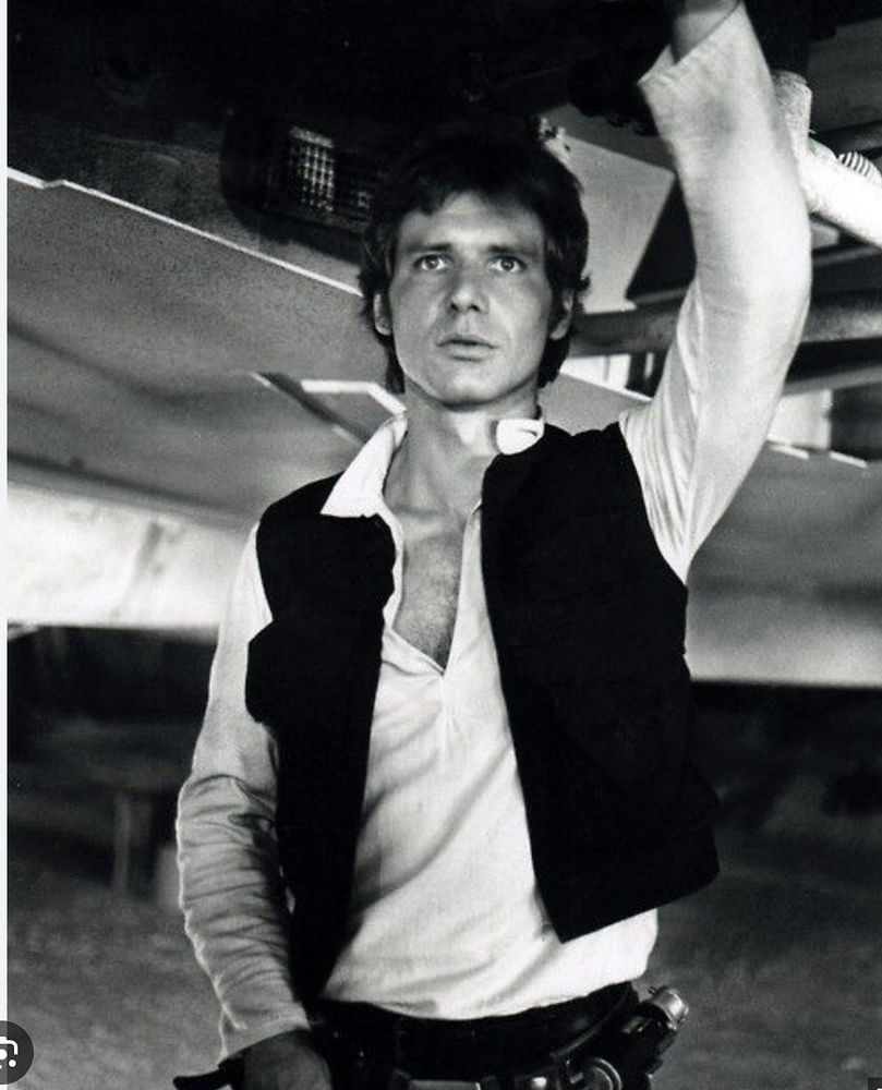 This is the most beautiful man who ever lived. Science has proven this. Believe me. They used microscopes, and ... altimeters. In this picture, Ford is not PLAYING the role of Han Solo, but WORKING the role of Han Solo. A casual hand on the fuselage of the Millenium Falcon tells us he knows how to take care of her fuselage. And probably our fuselage. The shirt, with five space-buttons open, tells us, yes, he CAN be a man of action - but he would also do a cracking "Addicted To Love" at the cantina karaoke session. He's the Ford we'd all like to wade into, up to our knees. We love him. He knows.