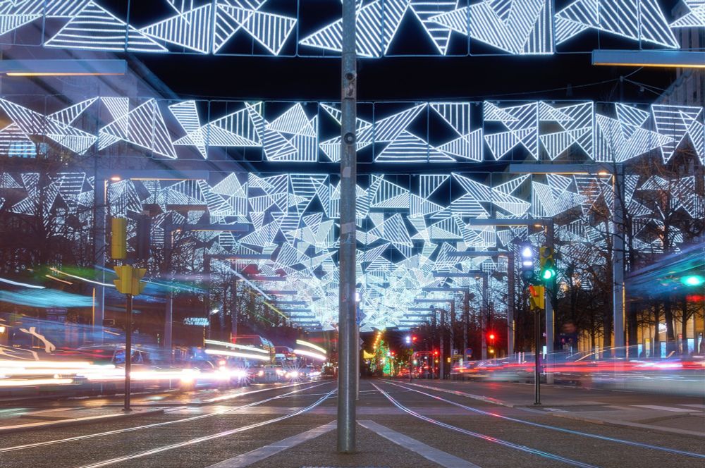A long street full of Christmas lights and traffic