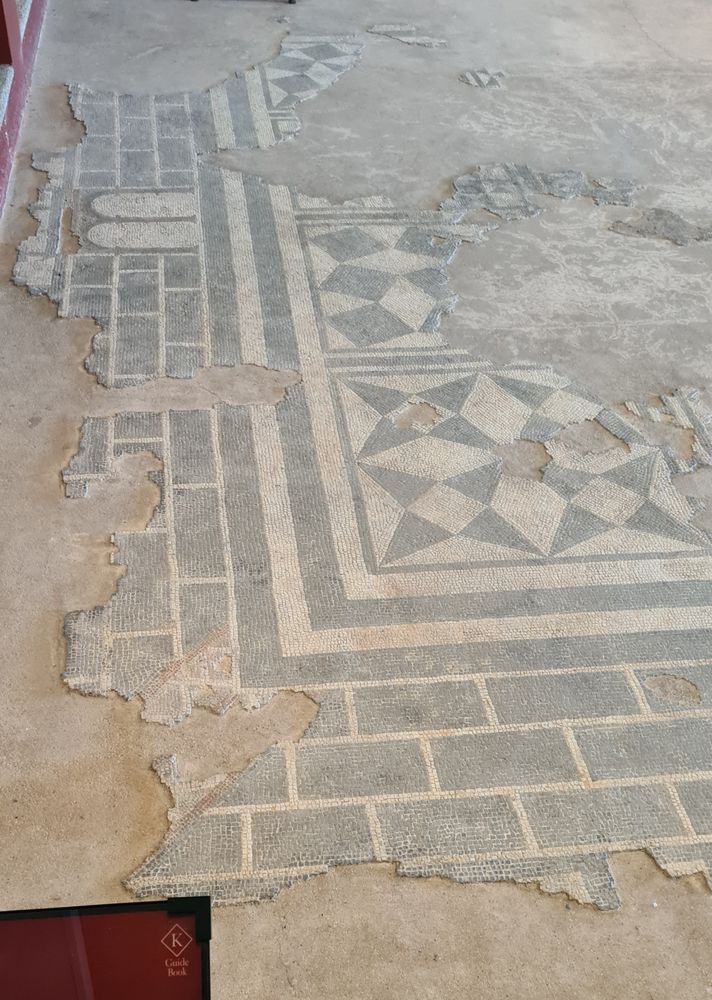 a black and white mosaic with interesting square based patterns in the inside of a city wall pattern! there is even a gateway in what would have been the middle of the left hand side