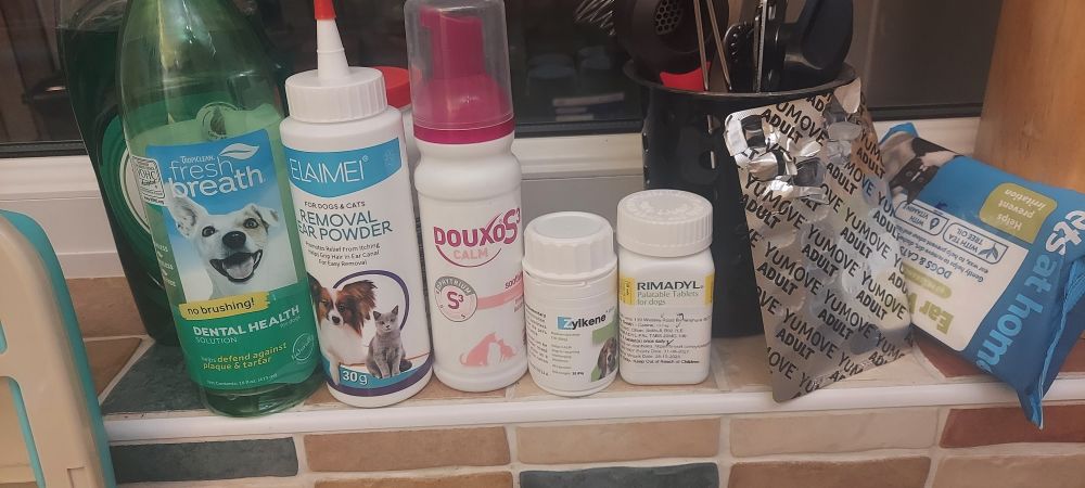 A shelf filled with potions and pills for dog health 