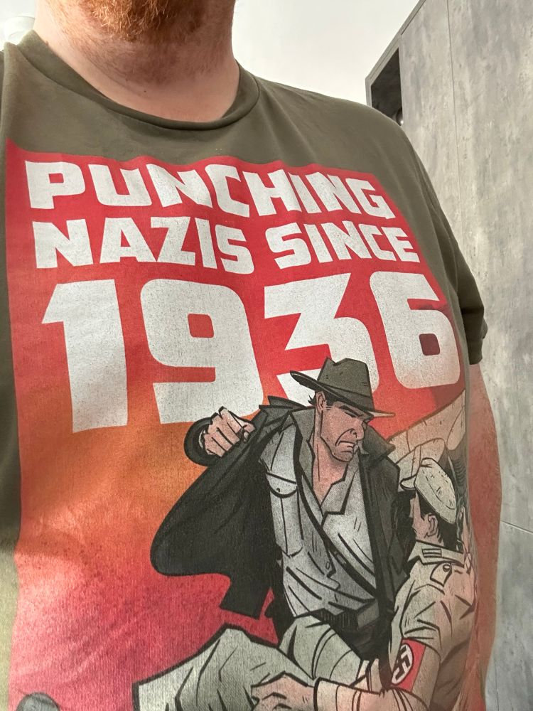 A T-shirt with a cartoon showing Indiana Jones punching a Nazi. The caption reads “Punching Nazis since 1936.”

This T-shirt is available from the brilliant Tokyo Sexwhale. His website is infinitebacon.com, where he sells great art prints and T-shirts. 