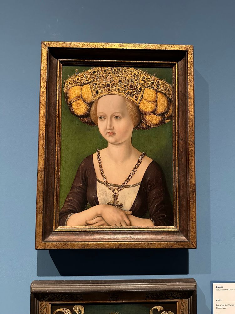 A renaissance painting of a woman with a very, very large hairstyle, who frankly looks a bit disappointed. 