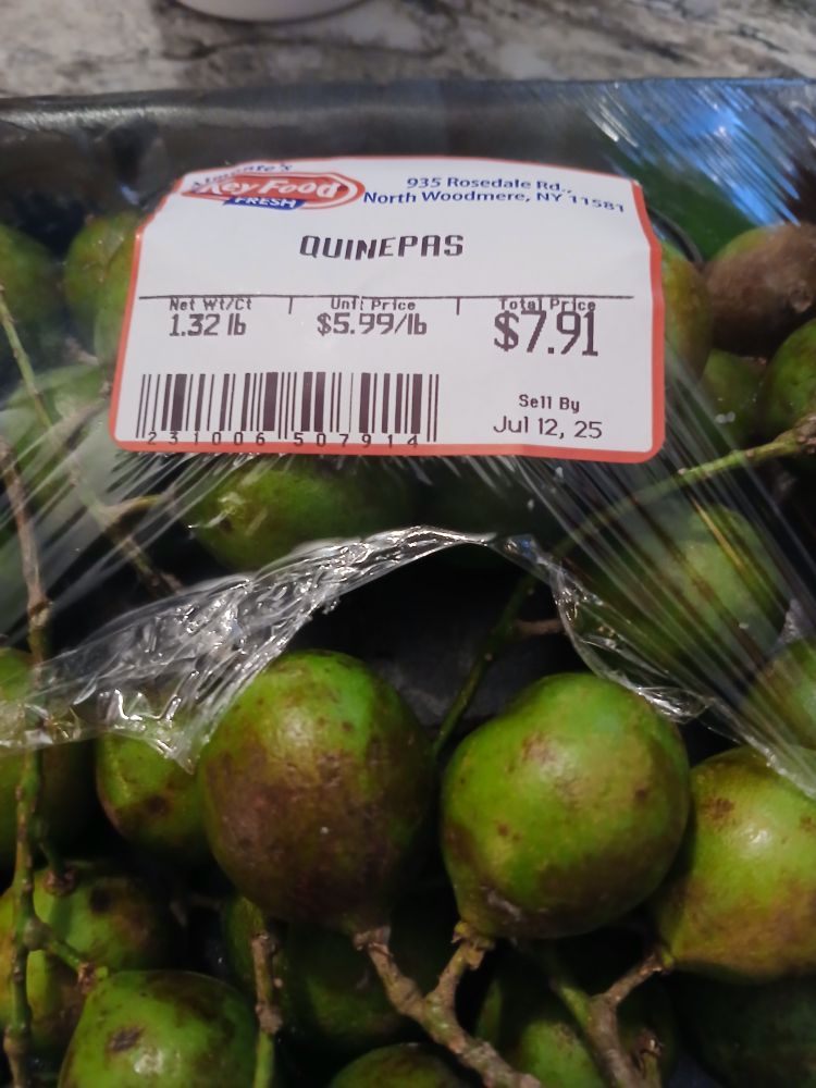 Package of quenepas, some covered by plastic w/a price tag 