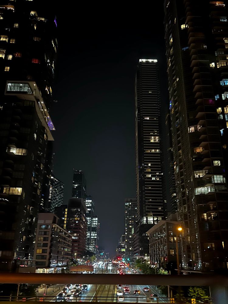 Looking down the street at night in Toronto.  Lit buildings on either side of the street