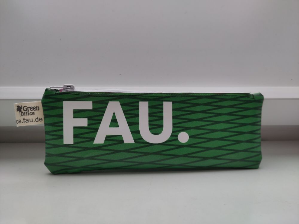 Ein grünes Federmäppchen auf dem die Buchstaben F, A und U stehen, was Friedrich-Alexander-Universität bedeutet.