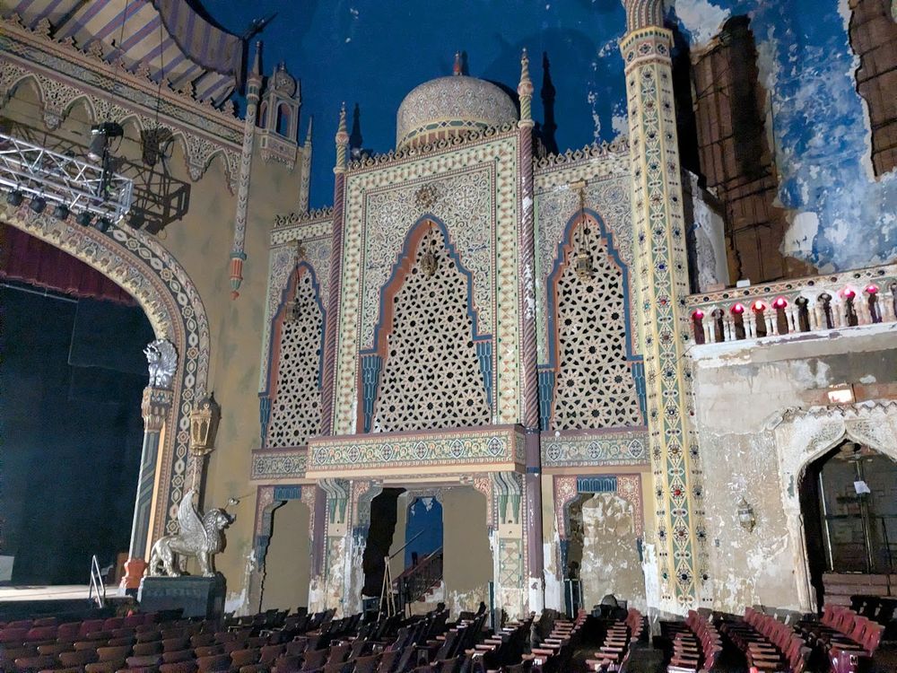 A large decorative piece on a theater wall, covered in intricate and colorful Moorish style details, roughly in the shape of a building 