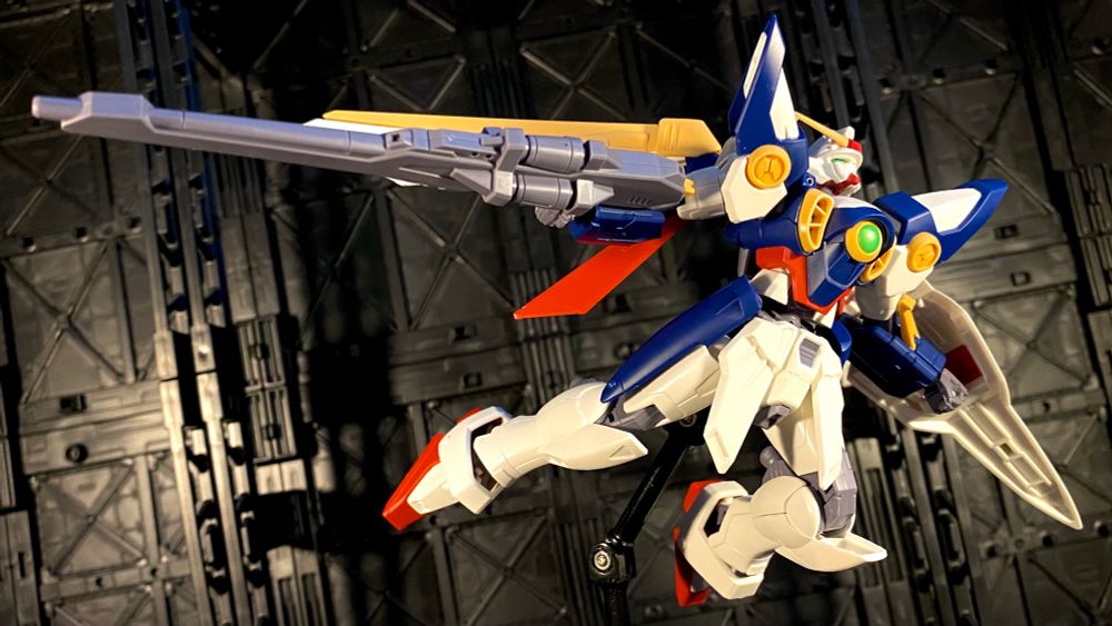 Entry Grade (EG) Wing Gundam, on display stand in a soaring pose