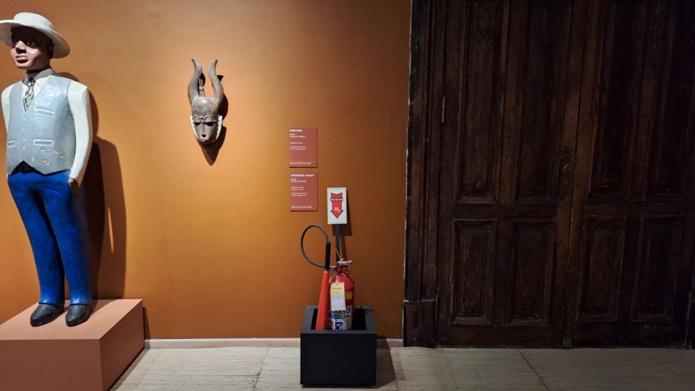 Extintor de incêndio dentro de uma exposição no CCBB RJ sobre ancestralidade africana. 