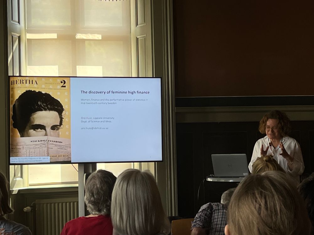 Orsi Husz presenting on the performative power of statistics on “feminine finance” in postwar Sweden, showing a slide with female statistical researcher behind the front page of a financial gazette.