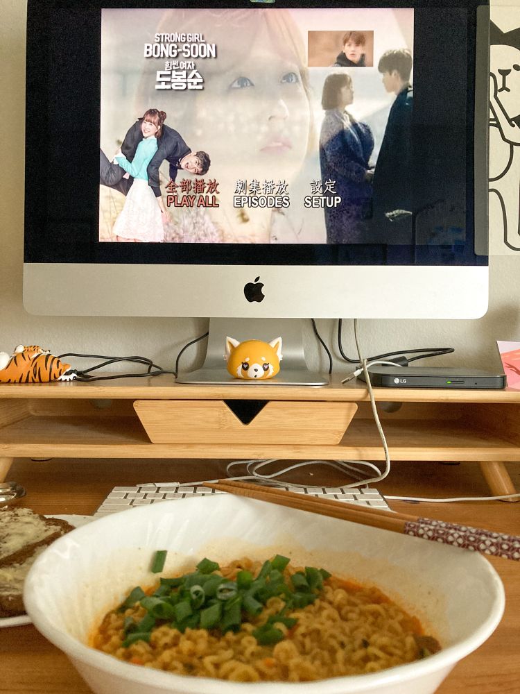 Bowl of spicy ramen in front of a computer playing “Strong Woman Do Bong Soon” 