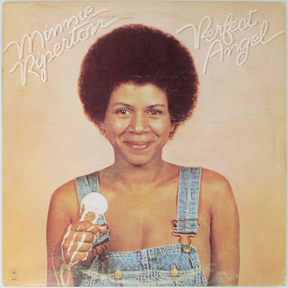 Album cover for Perfect Angel by Minnie Riperton, featuring Ms. Riperton in jean overalls holding a fast melting vanilla ice cream cone in one hand whilst smiling straight into the camera. The album is pure joy and bliss to me.