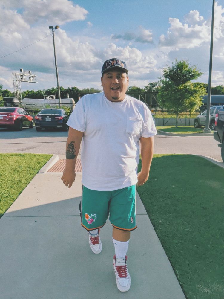 Kevin walking with hat and shorts on