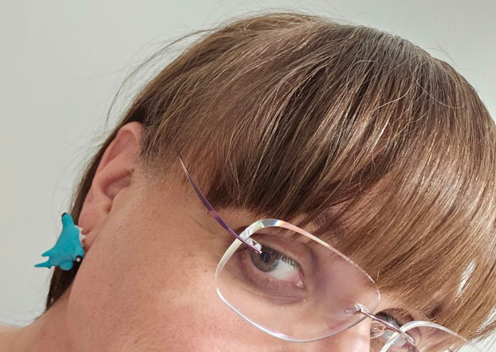 Me, NOT AT WORK, so I'm wearing my glasses. An adorable little hammerhead shark is biting my ear and catching a ride with me. 
